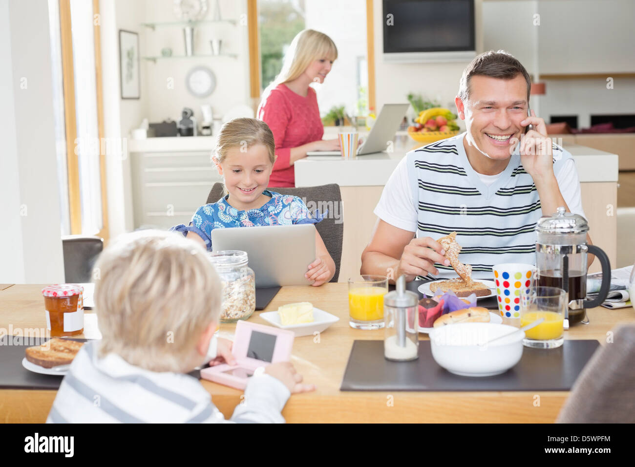 Familie mit Technologie beim Frühstück Stockfoto