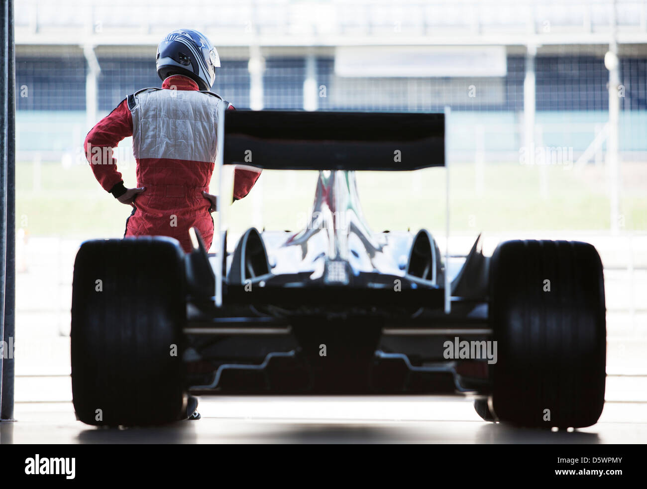 Racer stehend mit Auto in garage Stockfoto