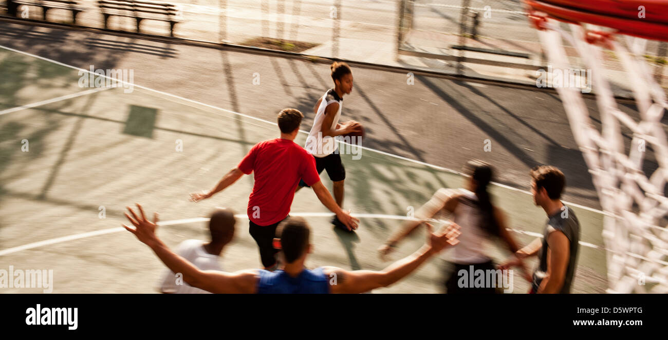 Männer spielen Basketball auf Platz Stockfoto