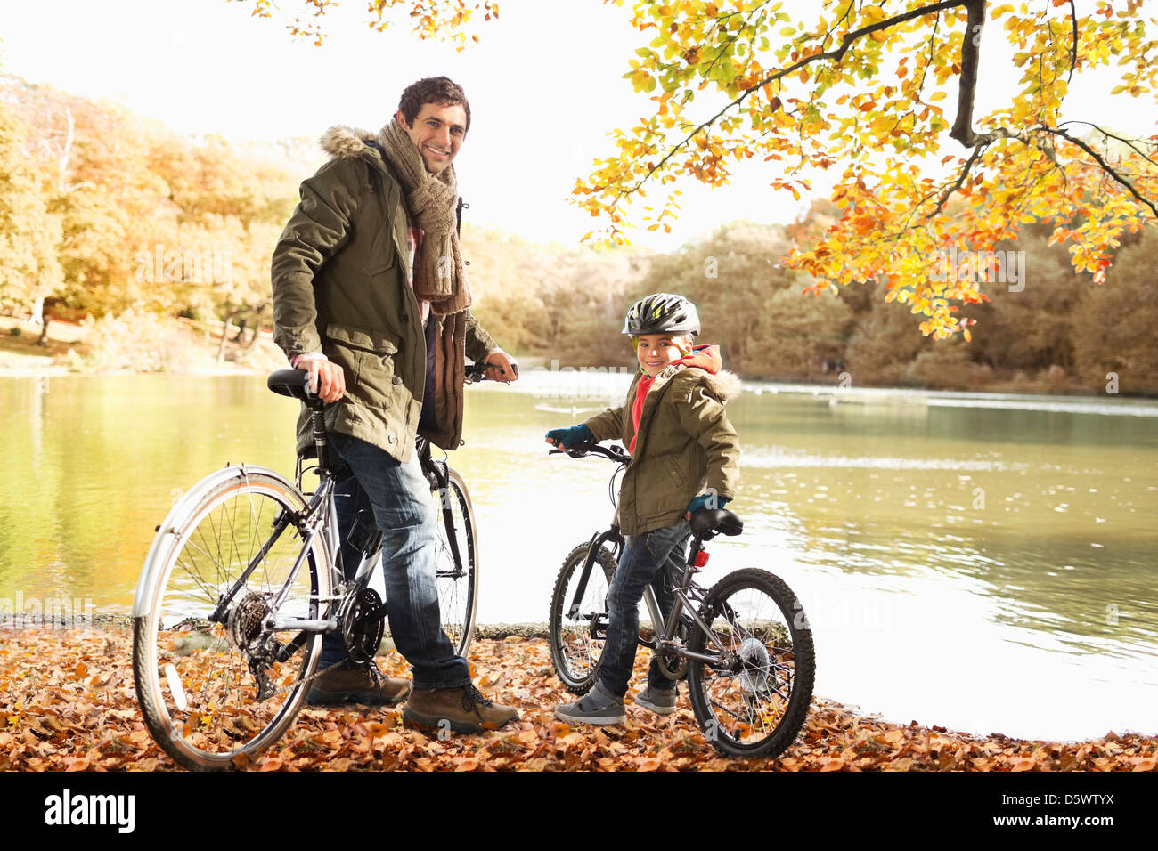 Vater und Sohn sitzen auf dem Fahrrad im park Stockfoto