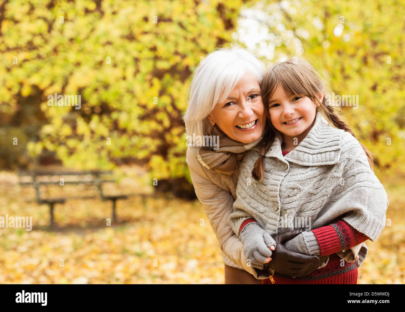 Ältere Frau und Enkelin lächelnd in park Stockfoto