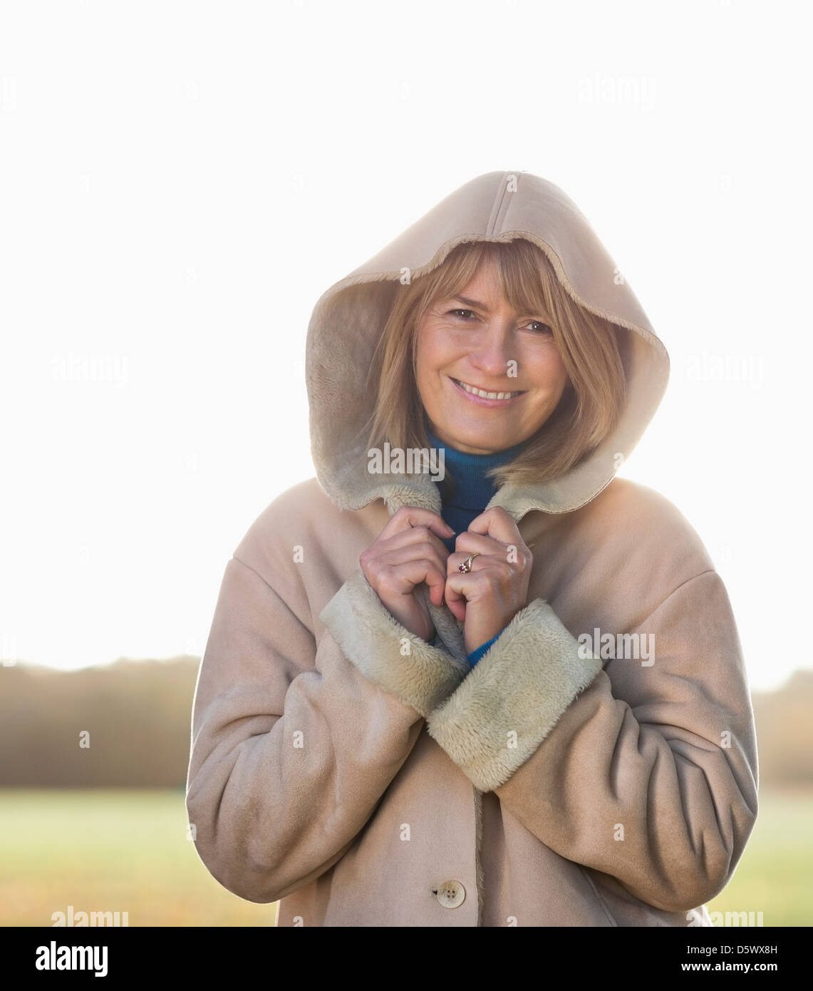 Ältere Frau, die im Freien stand lächelnd Stockfoto