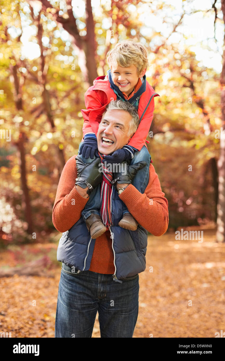 Älterer Mann mit Enkel auf Schultern im park Stockfoto