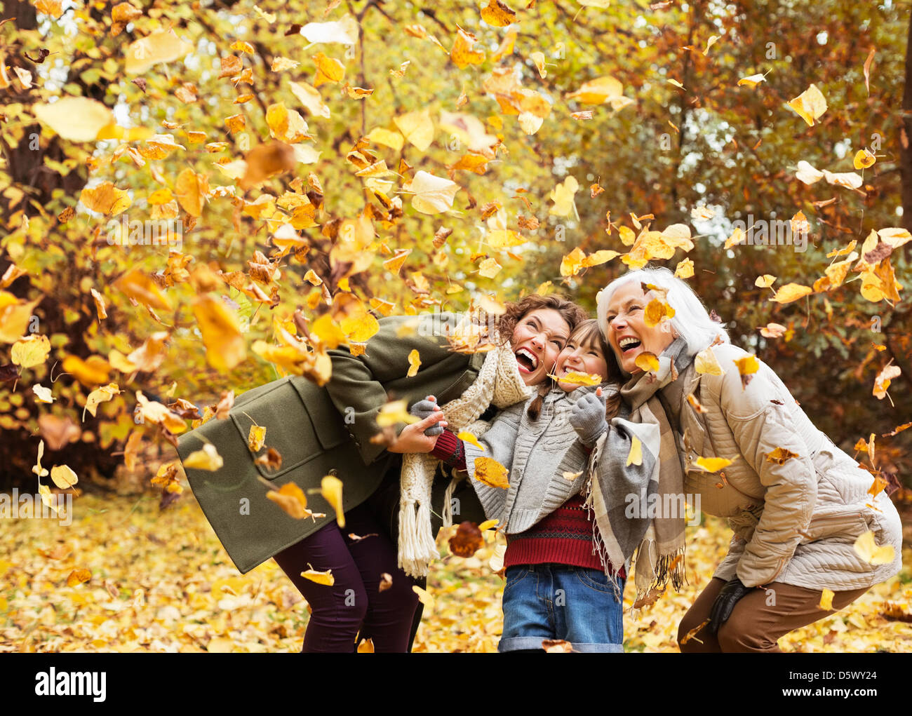 Drei Generationen von Frauen spielen im Herbstlaub Stockfoto