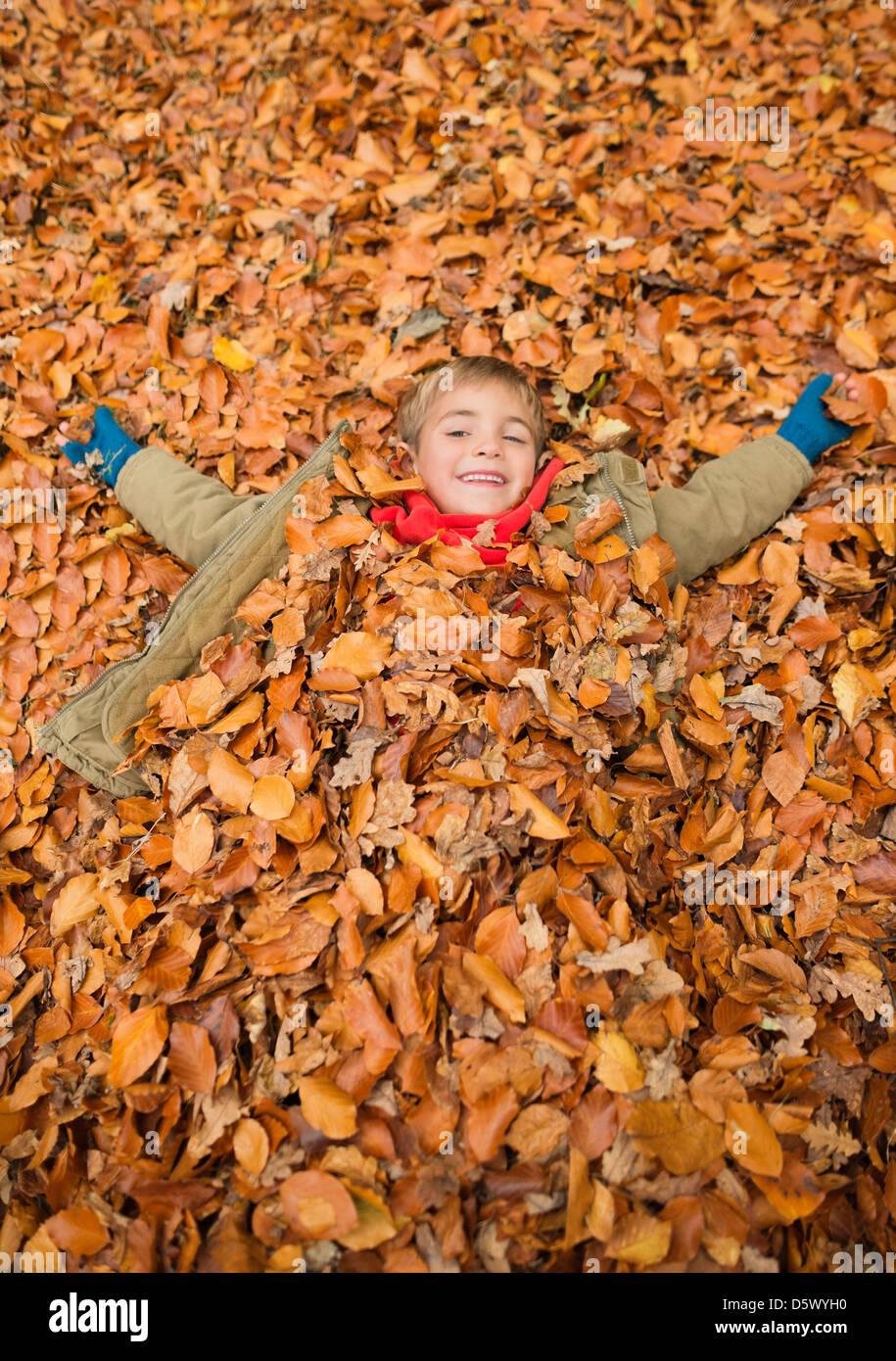 Junge im Herbstlaub Stockfoto
