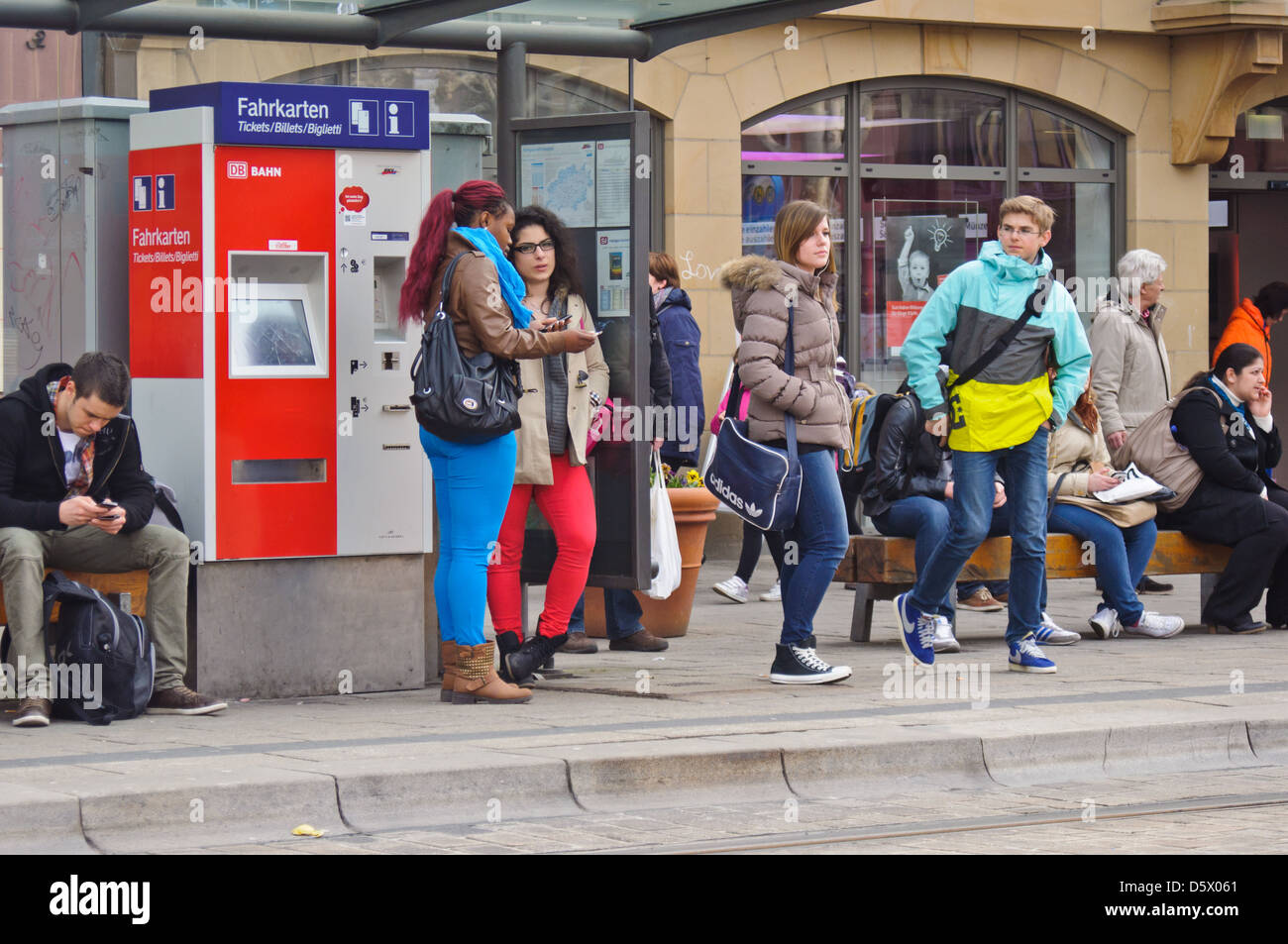 Pendler, viele Leute warten an einer Bushaltestelle, Zwischenstation. Moderne Deutsche Bahn Ticket Automaten – Heilbronn Deutschland Stockfoto