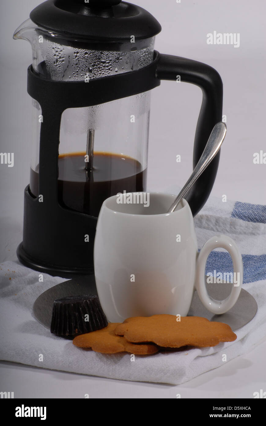 Kaffee, drücken Sie traditionelle französische Kaffeemaschine und kleine weiße Tasse mit einem silbernen Löffel, Schokolade und Kekse Stockfoto