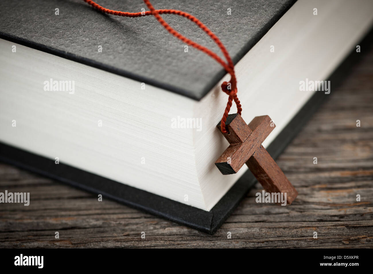 Nahaufnahme des hölzernen Christian Kreuz Halskette neben Bibel Stockfoto