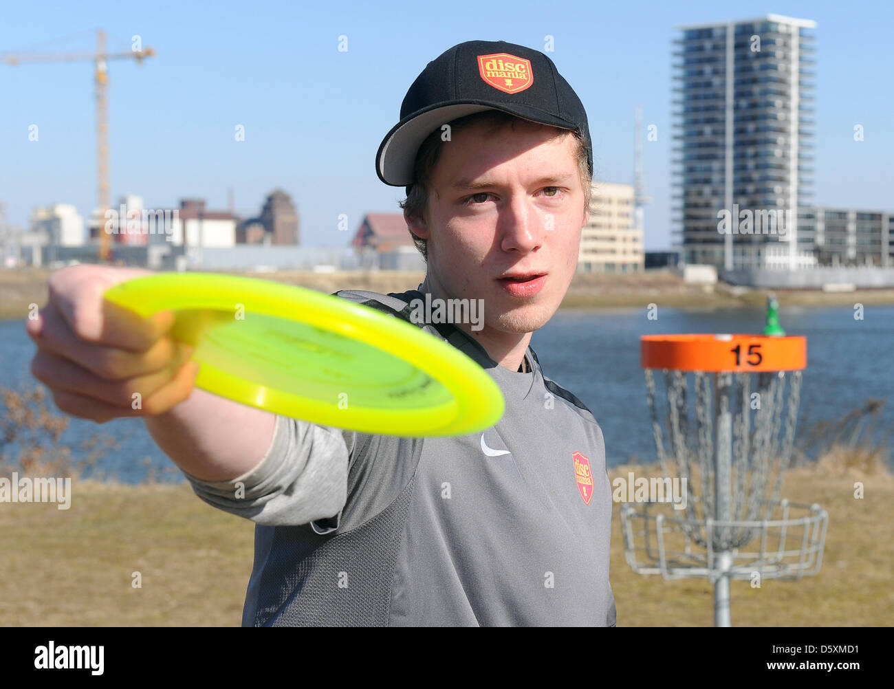 Europameister im Disc-Golf Simon Lizotte zeigt Disk Gold mit seiner Ausrüstung im Feld Disc Golf am Weseruferpark in Bremen, Deutschland, 2. April 2013. Das Spiel gespielt mit einer Art von Frisbee Scheibe folgt die Regeln des Golfsports indem man die Scheibe in das Netz mit der geringsten Anzahl an Würfen. Foto: Ingo Wagner Stockfoto