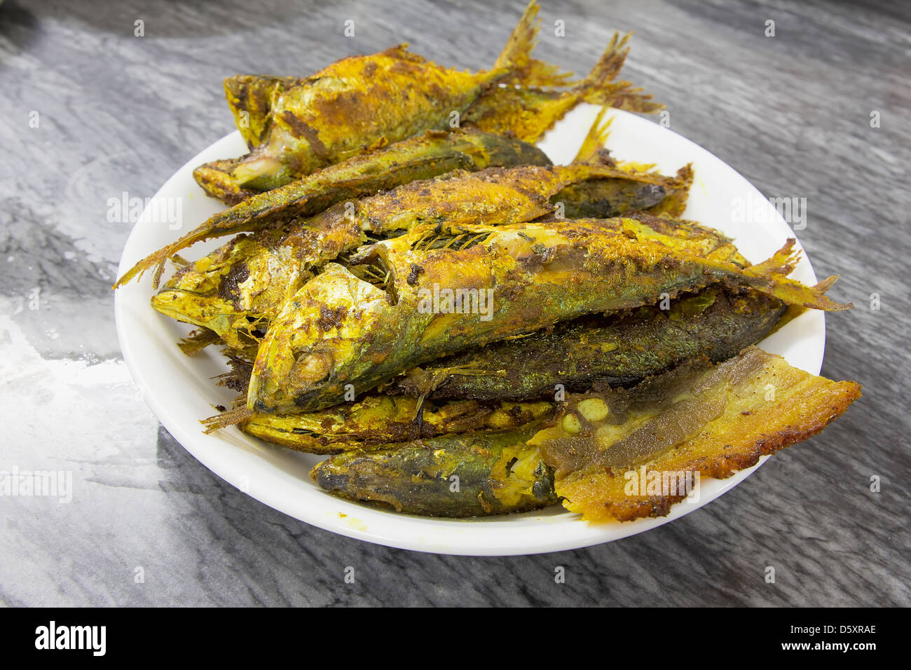 Frittierte Selar Kuning Fisch mit Curry Gewürzen abgeschmeckt Stockfoto