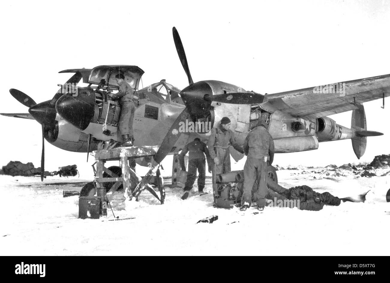 Rauen Feld entstehen, schwierigen Arbeitsbedingungen für 9 Air Force Wartungspersonal. Hier eine Crew bereitet eine externe Heizung zu verwenden, um eine Lockheed P-38 "Lightning frozen Motor so begann es können, 24.02.1945, Belgien, zu warm. Stockfoto