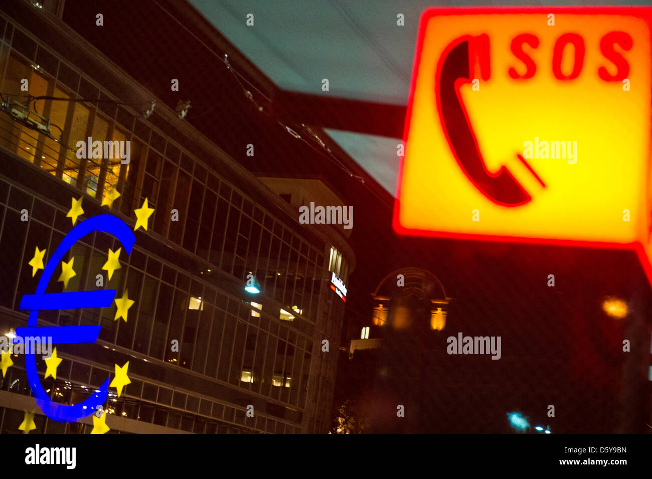 Die Euro-Skulptur spiegelt sich in der Straßenbahn-Haltestelle "Willy-Brandt-Platz" neben einem SOS-Symbol in Frankfurt Main, Deutschland, 16. Oktober 2012. Foto: Nicolas Armer Stockfoto