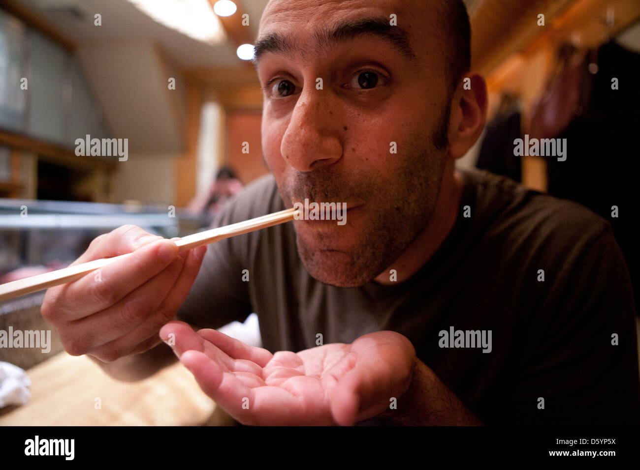 Menschen mit Stäbchen essen Stockfoto