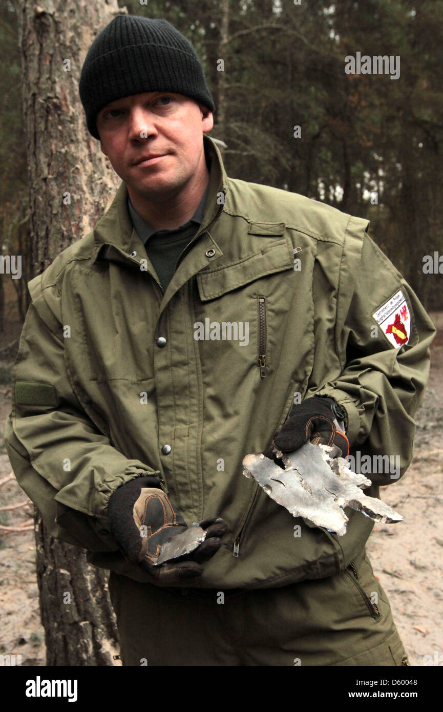 Abriss-Experten Mike Schwitzke hält Fragmente der Bombe Blindgänger vor einem Bombentrichter in der Nähe von Stahnsdorf, Deutschland, 7. November 2012. Eine 250 kg Fliegerbombe aus dem zweiten Weltkrieg gefunden worden war, und dann Contoledly zur Detonation gebracht hier. Foto: NESTOR BACHMANN Stockfoto