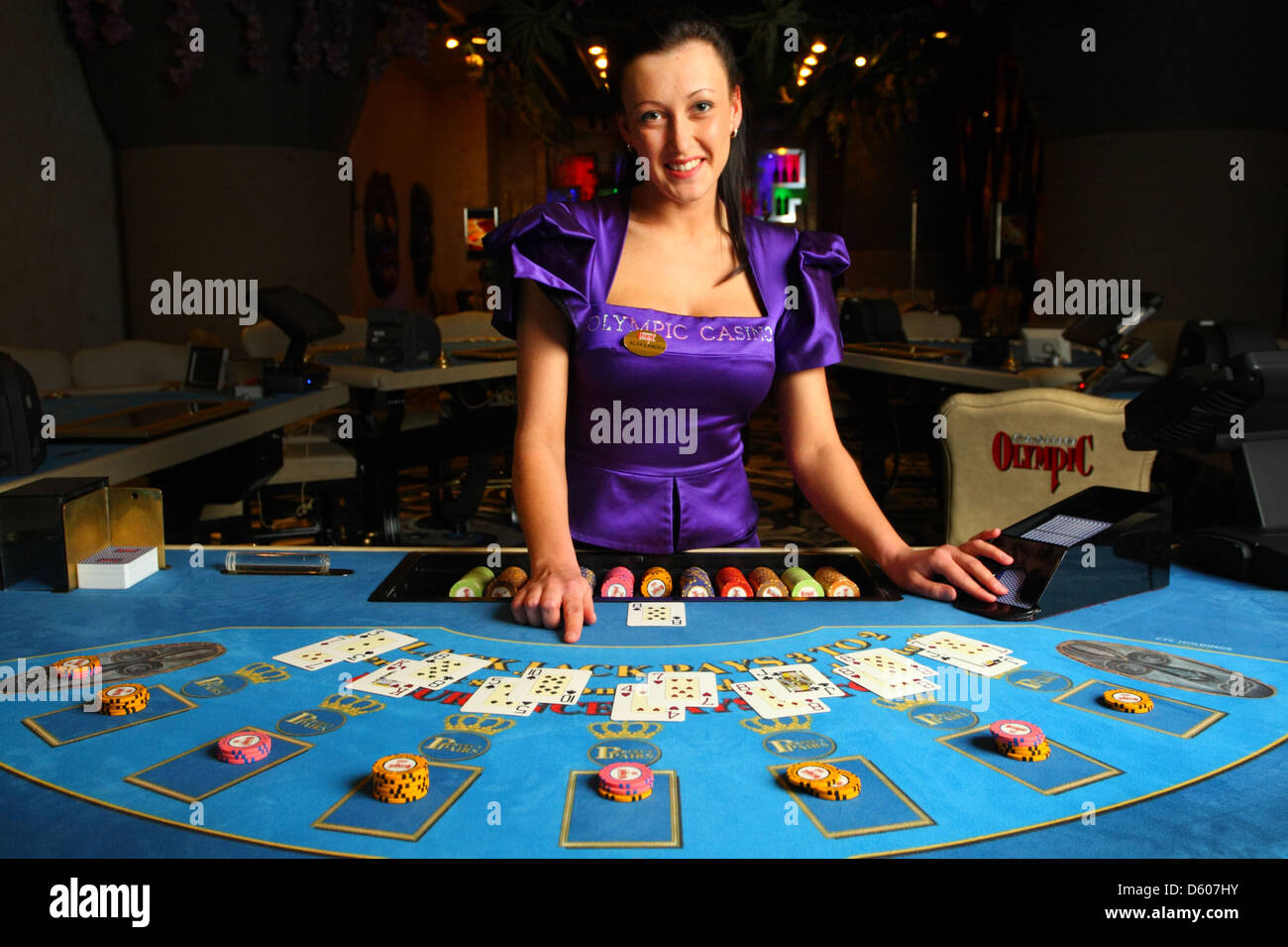 Lächelnde Händler, Croupier zeigt Karten im Casino am Blackjack-Tisch. Europa Stockfoto