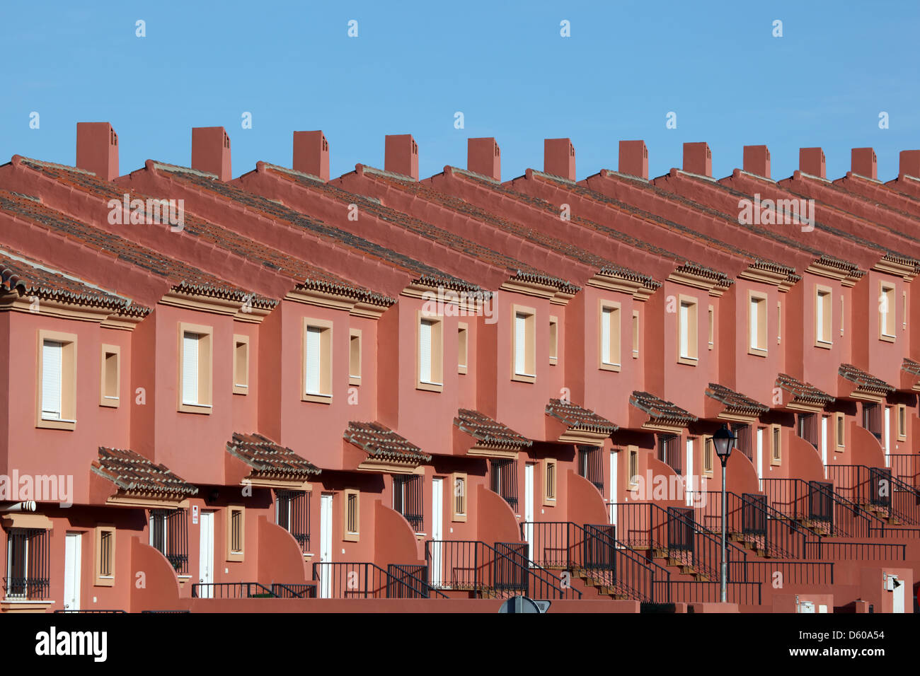 Reihe von roten Wohnhäusern in einer Wohnsiedlung in Spanien Stockfoto