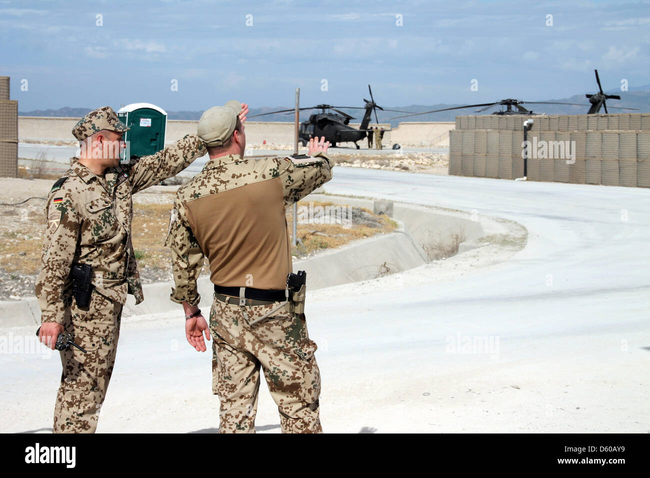 Zwei deutsche Soldaten stehen vor einem Hubschrauberlandeplatz am militärischen Camp Kunduz in Kunduz, Afghanistan, 29. März 2013. US-Hubschrauber sind im Hintergrund zu sehen. Foto: Can Merey Stockfoto
