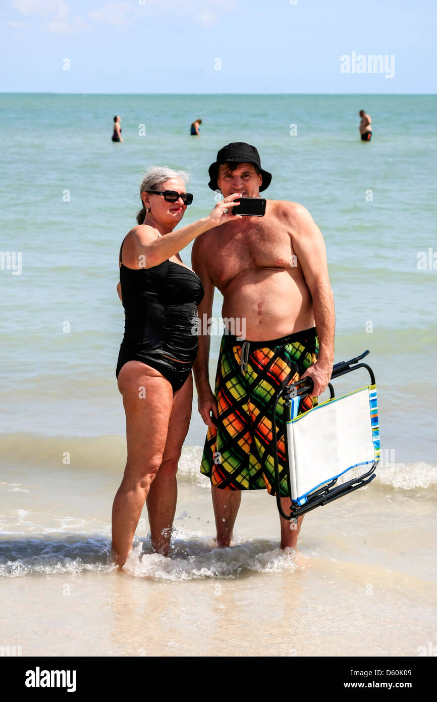 Paar sich dort eigene Fotos mit einem iPhone in Urlaub auf Sanibel Island Florida Stockfoto
