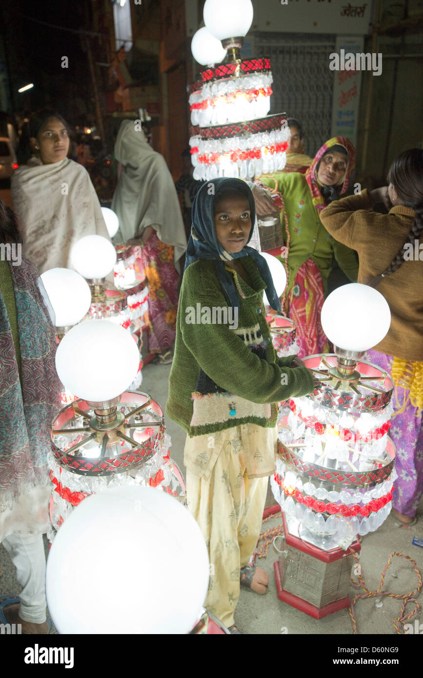 Eine Gruppe von Lampenträger genießen eine Pause während einer Hochzeit Parade in Udaipur, Rajasthan, Indien Stockfoto