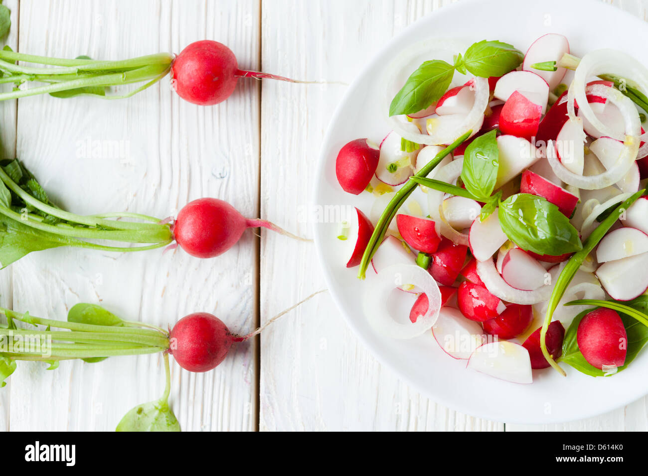 Salat von frischen Radieschen und Rettich mit Blätter auf dem Tisch, Nahaufnahme Stockfoto