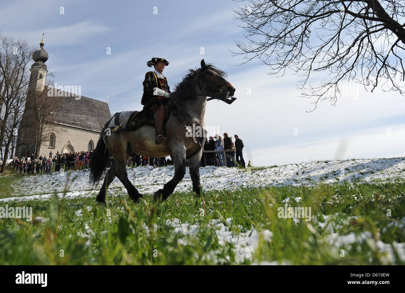 Ein Mann fährt vorbei an der Ettendorf Kirche während der Oster-Fahrt zu Ehren des Heiligen Georg in Traunstein, Deutschland, 9. April 2012. Der Umzug mit Pferden ist eine Tradition in der Region. Foto: ANDREAS GEBERT Stockfoto