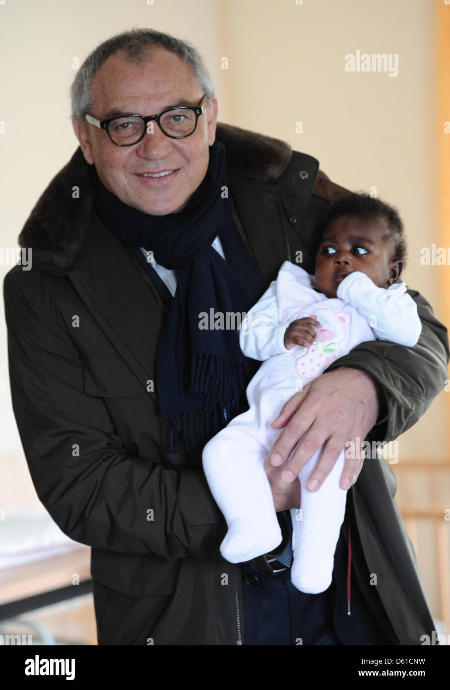 Wolfsburg-Coach und Vorstandsvorsitzender der Phytokids-Stiftung für verwahrloste Kinder Felix Magath, hält sechs Monate alten Emanuela aus Ghana in der Unterkunft Mattkamp in Hamburg, Deutschland, 16. April 2012. Magath präsentiert einen VW-Bus der Phytokids-Stiftung, der Kind-Schutz-Liga. Foto: Christian Charisius Stockfoto