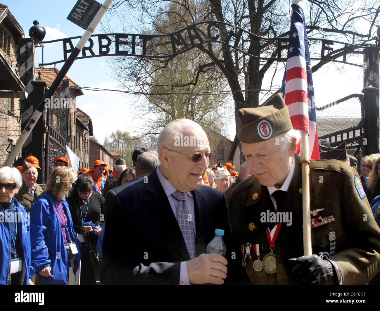 Tschechische geboren Holocaust-Überlebender Irving Roth (L) und US-Veteran Frederick Carrier (R, mit US-Flagge) beteiligen sich an der "Marsch der lebenden" am Haupttor des ehemaligen deutschen Nazi-Tod Auschwitz, in Oswiecim, Polen, 19. April 2012. Mehrere tausend Menschen nehmen an der jährlichen Holocaust-Gedenken "Marsch der lebenden" Teil auf der Website der Kriegszeit Nazi-Vernichtungslager Auschwit Stockfoto