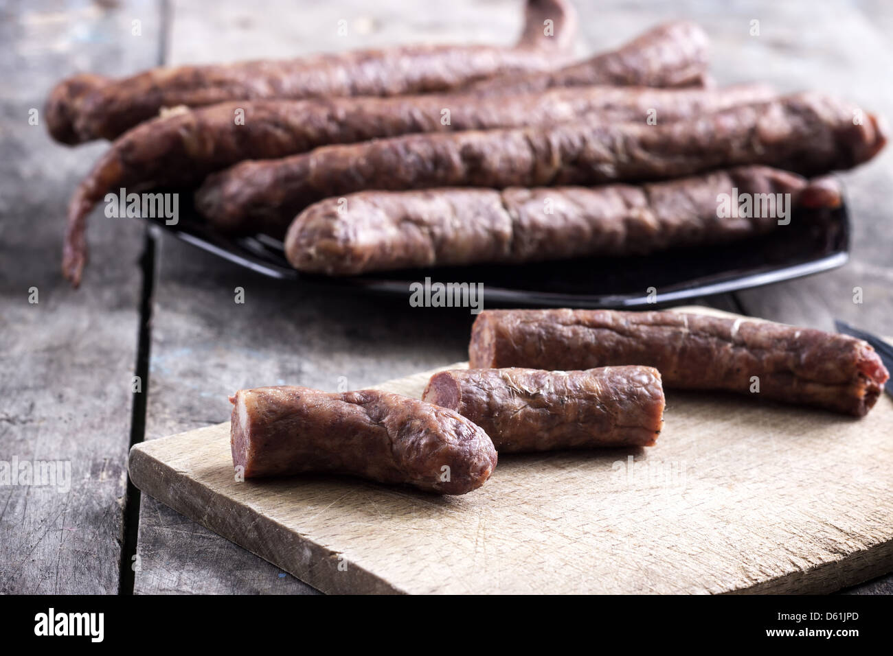 frische Sousages auf Messers Schneide an Bord in der Nähe Stockfoto