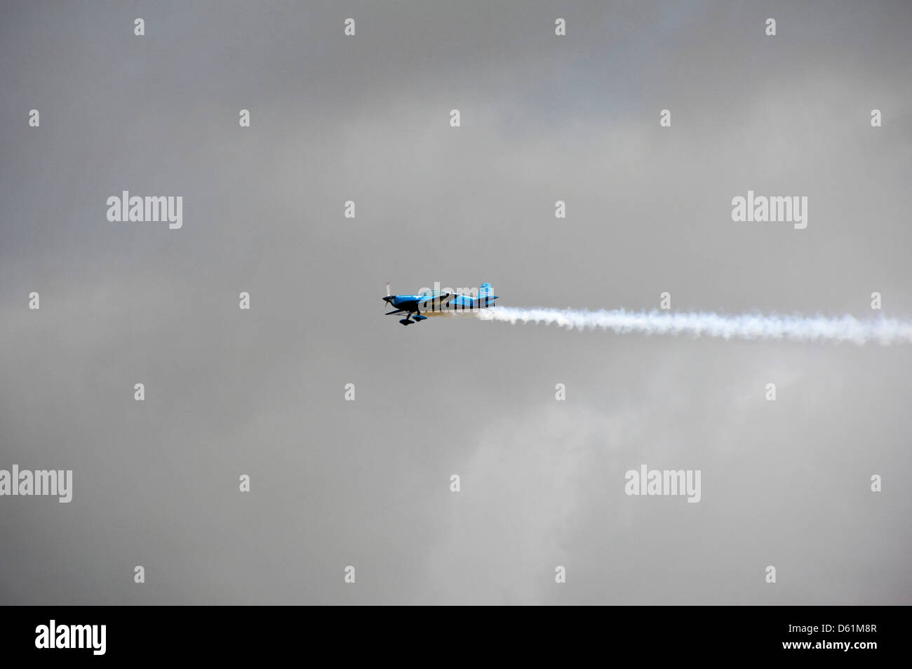 Horizontale Sicht auf eine Extra Flugzeugbau EA300 Eindecker mit einer Dampf-Spur während einer Flugschau fliegt. Stockfoto