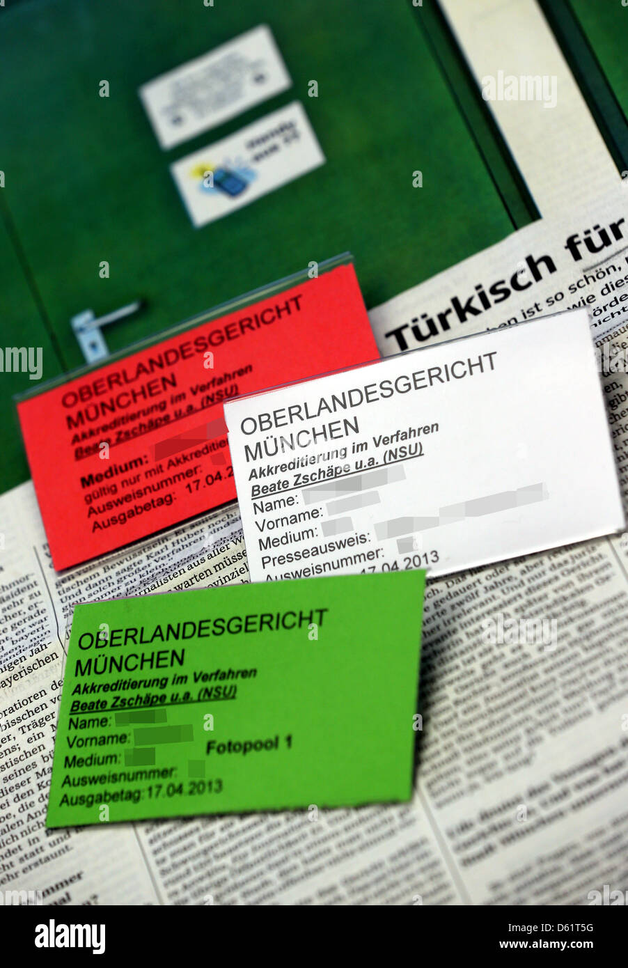 ILLUSTRATION - sitzen drei Akkreditierungs-Badges Journalisten von der NSU-Mordfall auf eine Zeitung in München, Deutschland, 11. April 2013. Das OLG München konfrontiert Kritik über seine Akkreditierung nach türkische Medien leer ausgegangen waren. Foto: STEPHAN JANSEN Stockfoto