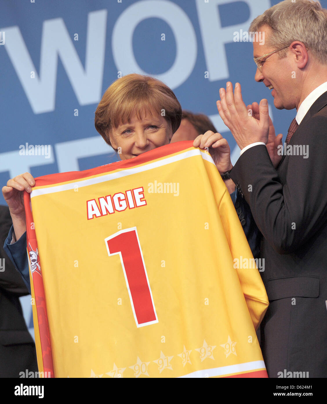 Deutsche Bundeskanzlerin Angela Merkel (L) hält ein Eishockey-Trikot mit ihrem Namen drauf bei einer Wahl-Veranstaltung in Düsseldorf, Deutschland, 11. Mai 2012. Die Christdemokraten halten ihr Ende der Kampagne Rallye in Düsseldorf. Foto: CAROLINE SEIDEL Stockfoto