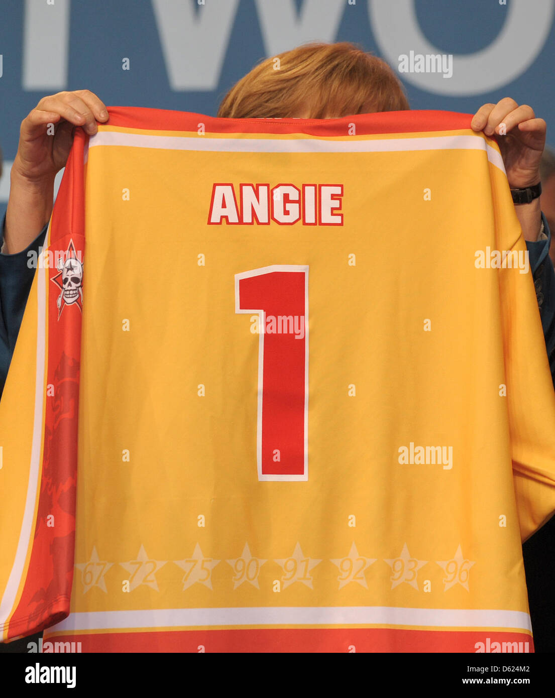 Deutsche Bundeskanzlerin Angela Merkel (L) hält ein Eishockey-Trikot mit ihrem Namen drauf bei einer Wahl-Veranstaltung in Düsseldorf, Deutschland, 11. Mai 2012. Die Christdemokraten halten ihr Ende der Kampagne Rallye in Düsseldorf. Foto: CAROLINE SEIDEL Stockfoto