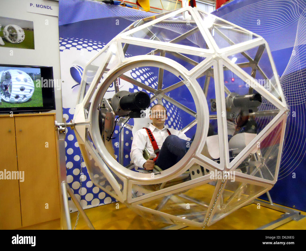 Österreicher Peter Mondl sitzt in seinem "Q-Gel," ausgesprochen "Kugel" (beleuchtet: Cube) auf der Erfindermesse (Erfinder Expo) in Genf, Deutschland, 10. April 2013. Die elektrisch angetriebene Fahrzeug schlägt wie eine übergroße Fußball über Wasser und ist eine Menge Spaß, nach Mondl. Foto: Thomas Burgmeister Stockfoto