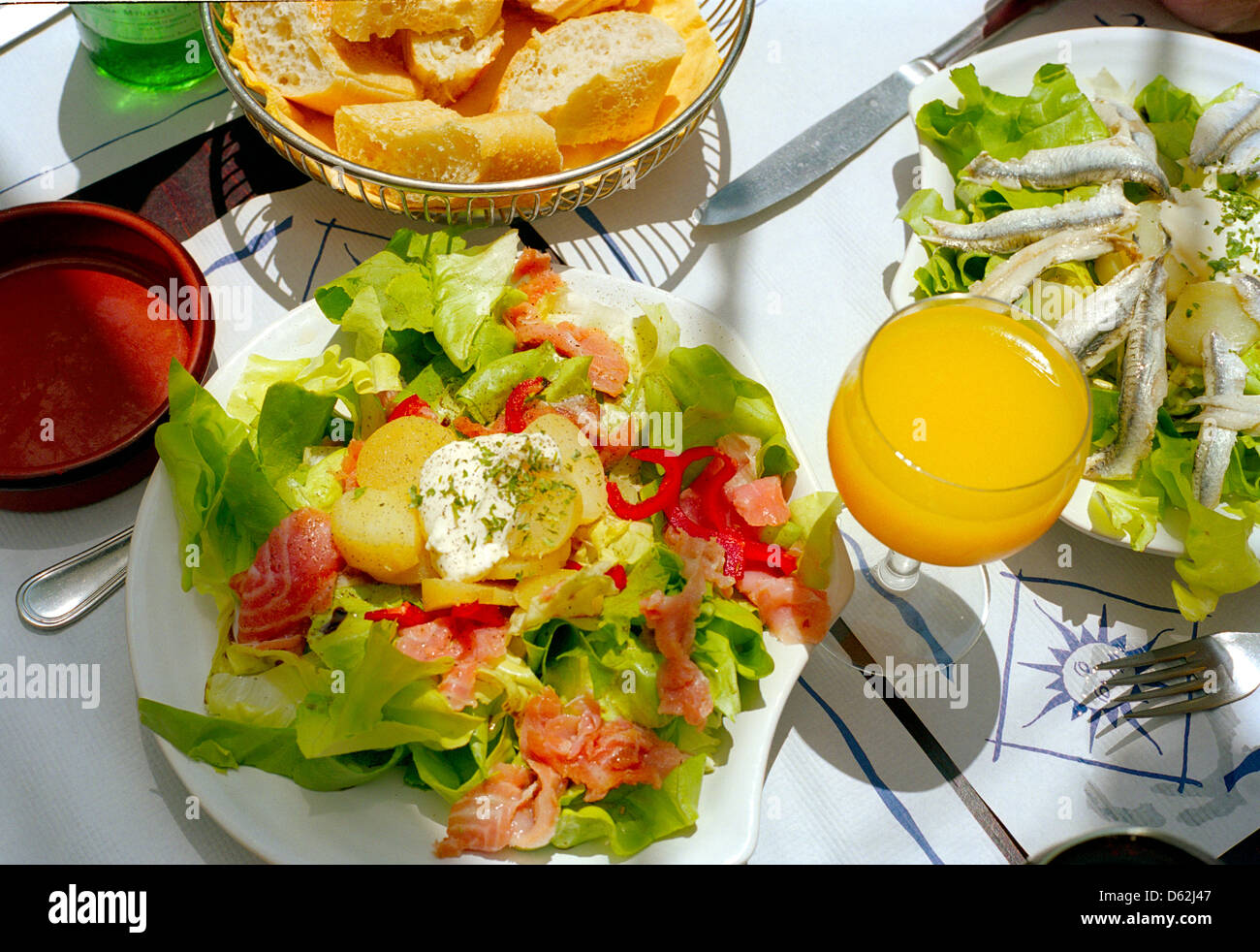 Geräucherter Lachs Salat mit einem Glas frisch gepressten Orangensaft in einem französischen Café - ein perfektes Mittagessen. Stockfoto