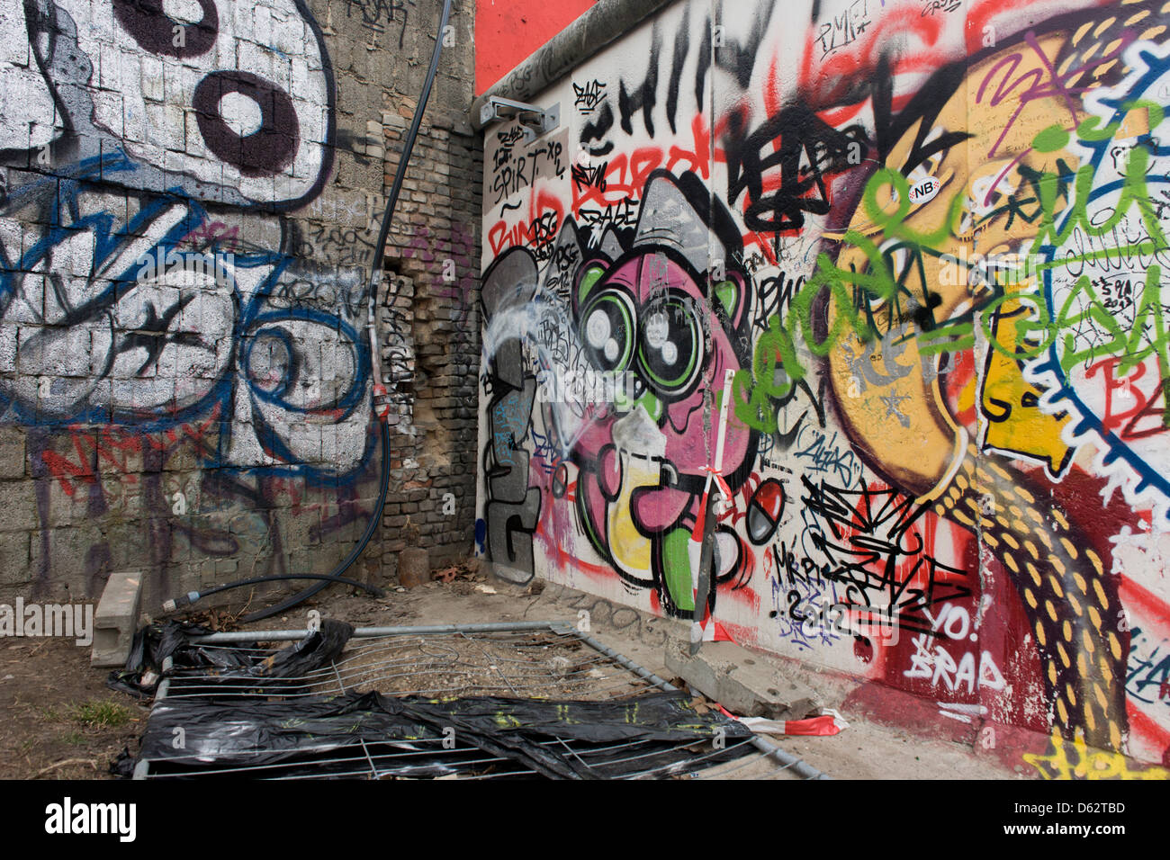 Wo junge deutsche einmal ihr Leben riskierten, schmücken Graffiti und Tags jetzt die Betonoberflächen der ursprünglichen Abschnitte der Berliner Mauer an der East Side Gallery auf Muhlenstrasse, Berlin. Die Website ist die ehemalige Grenze zwischen Ost und West Berlin während des Kalten Krieges. Die Berliner Mauer war eine Barriere, die von der Deutschen Demokratischen Republik (DDR, Ostdeutschland) ab dem 13. August 1961, gebaut, die völlig abgeschnitten (Landweg) West-Berliner aus den umliegenden Ostdeutschland und aus Ostberlin... (Mehr in Beschreibung). Stockfoto