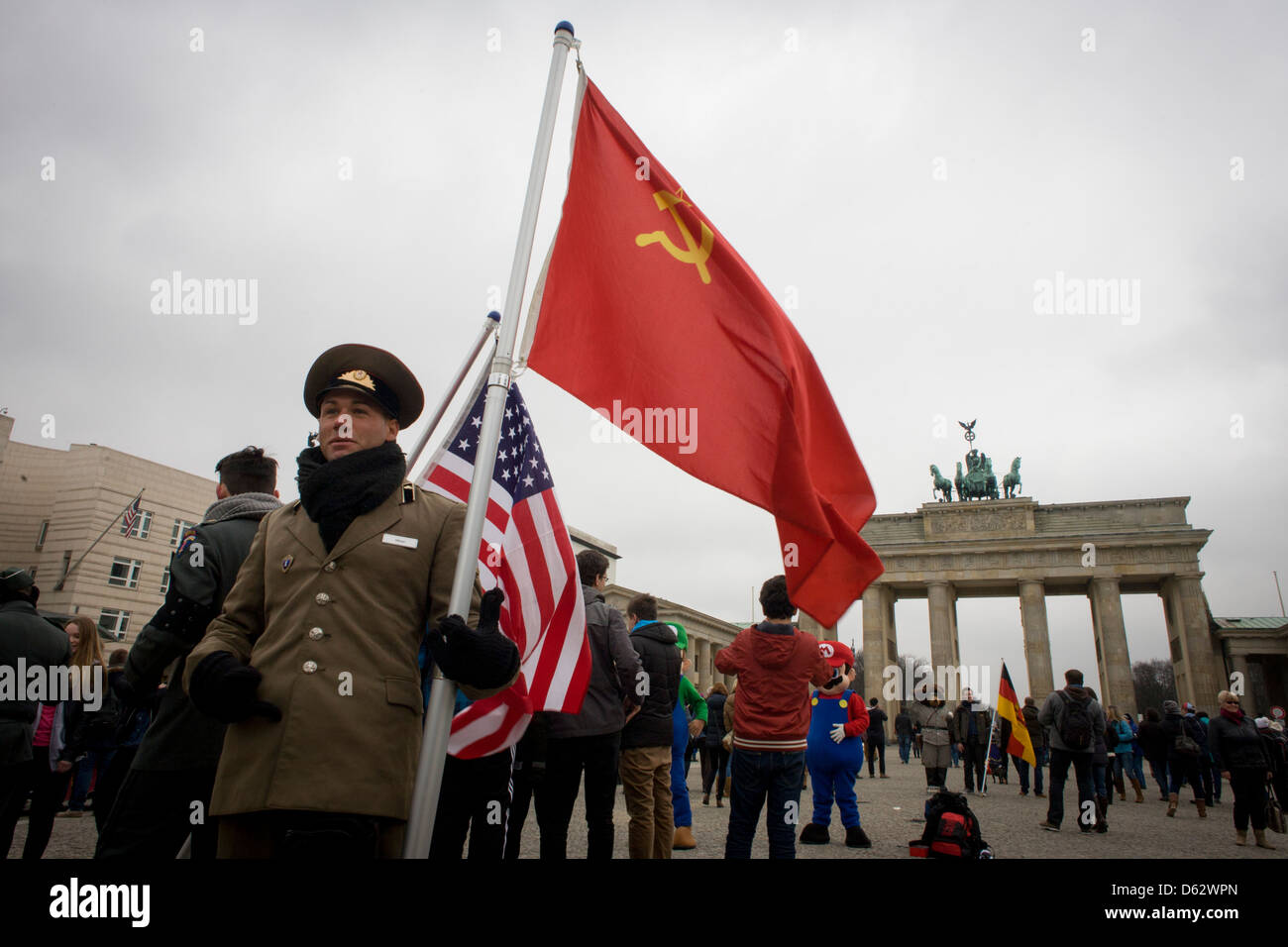 Akteure in USA und sowjetischen Armee-Uniformen halten Fahnen deutschen Geschichte während des zweiten Weltkrieges und später erzählen des Kalten Krieges - unter dem Brandenburger Tor, unter Den Linden in Berlin, Deutschland. Die Website ist in der Nähe der ehemaligen Grenze zwischen Ost und West Berlin während des Kalten Krieges. Hier wurde auch Berlin durch die Besatzungsmacht Sektoren der amerikanischen, britischen, französischen und sowjetischen Truppen nach dem 2. Weltkrieg getrennt. (Mehr in Beschreibung)... Stockfoto