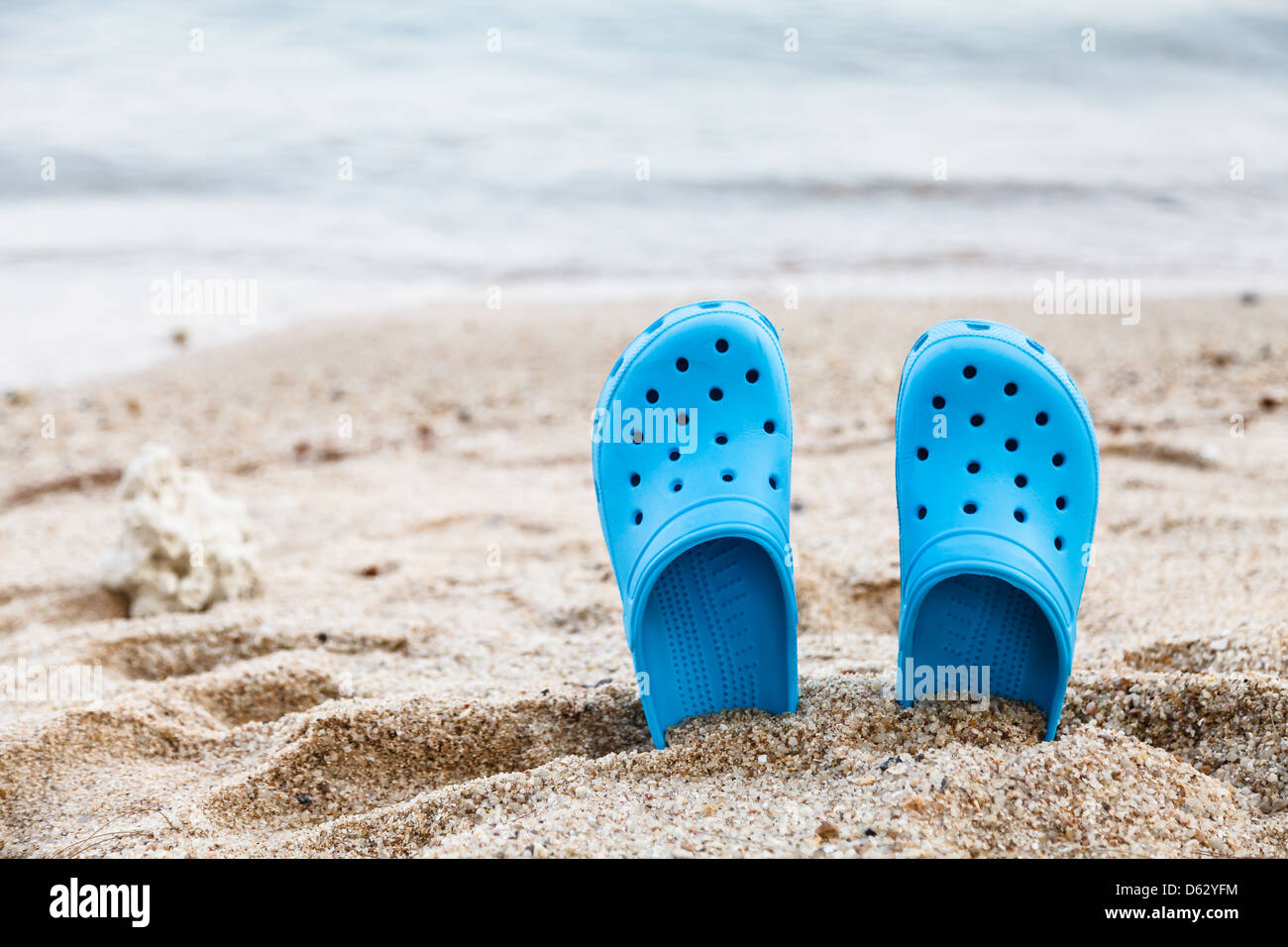Blaue Sandalen mit geringen Schärfentiefe am Strand Stockfoto