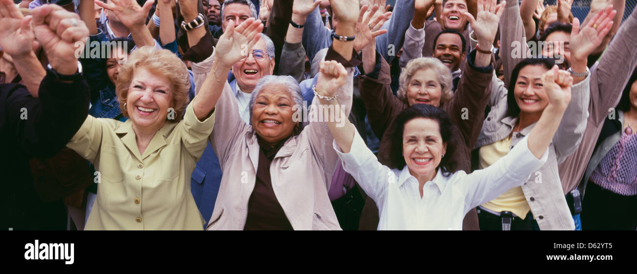 Große Gruppe von multi-ethnischen Menschen jubeln mit rms angehoben Stockfoto