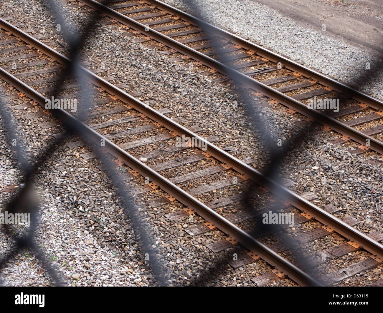 Blick auf Eisenbahnschienen durch Maschendrahtzaun Stockfoto