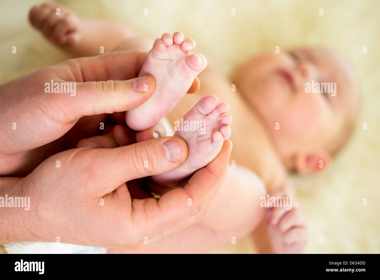 Vater oder Arzt kleine Babys Fuß massieren Stockfoto