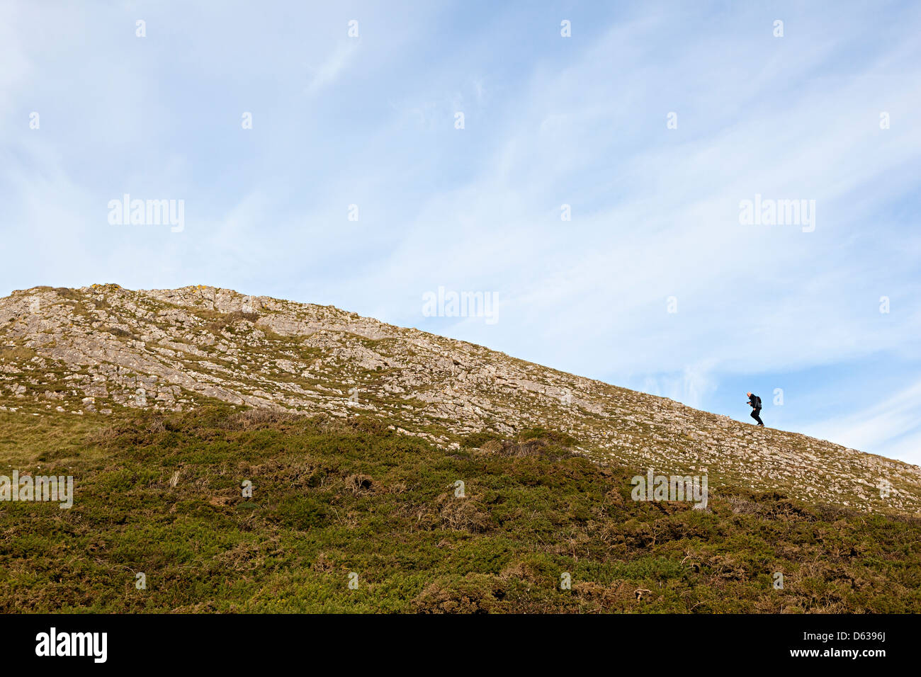 Person zu Fuß hinauf auf Wurm Kopf, Rhossili, Gower, Wales, UK Stockfoto