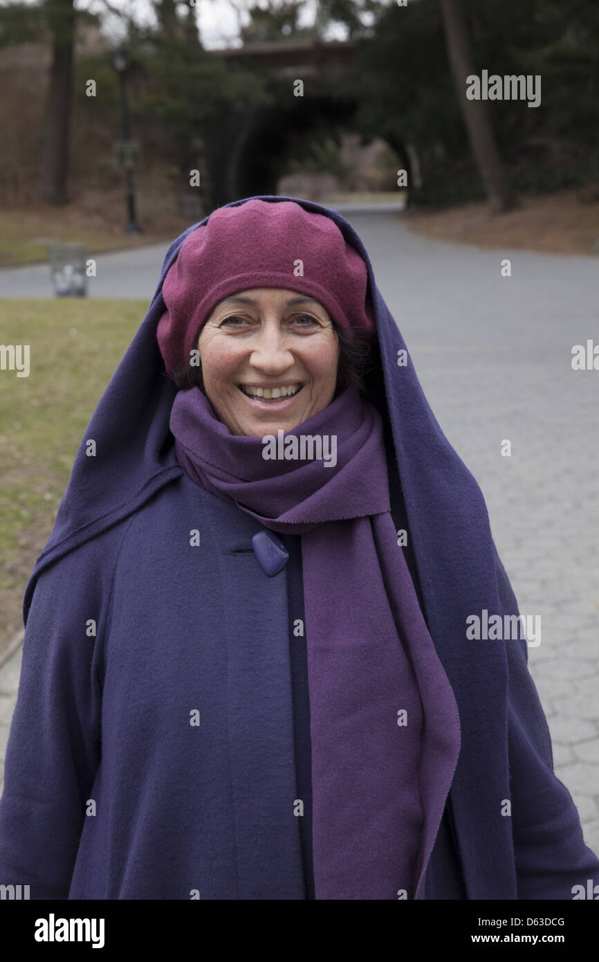 Lächeln 60 Jahre alte Frau in Prospect Park an einem kalten, stürmischen Tag im Frühling, Brooklyn, NY. Stockfoto