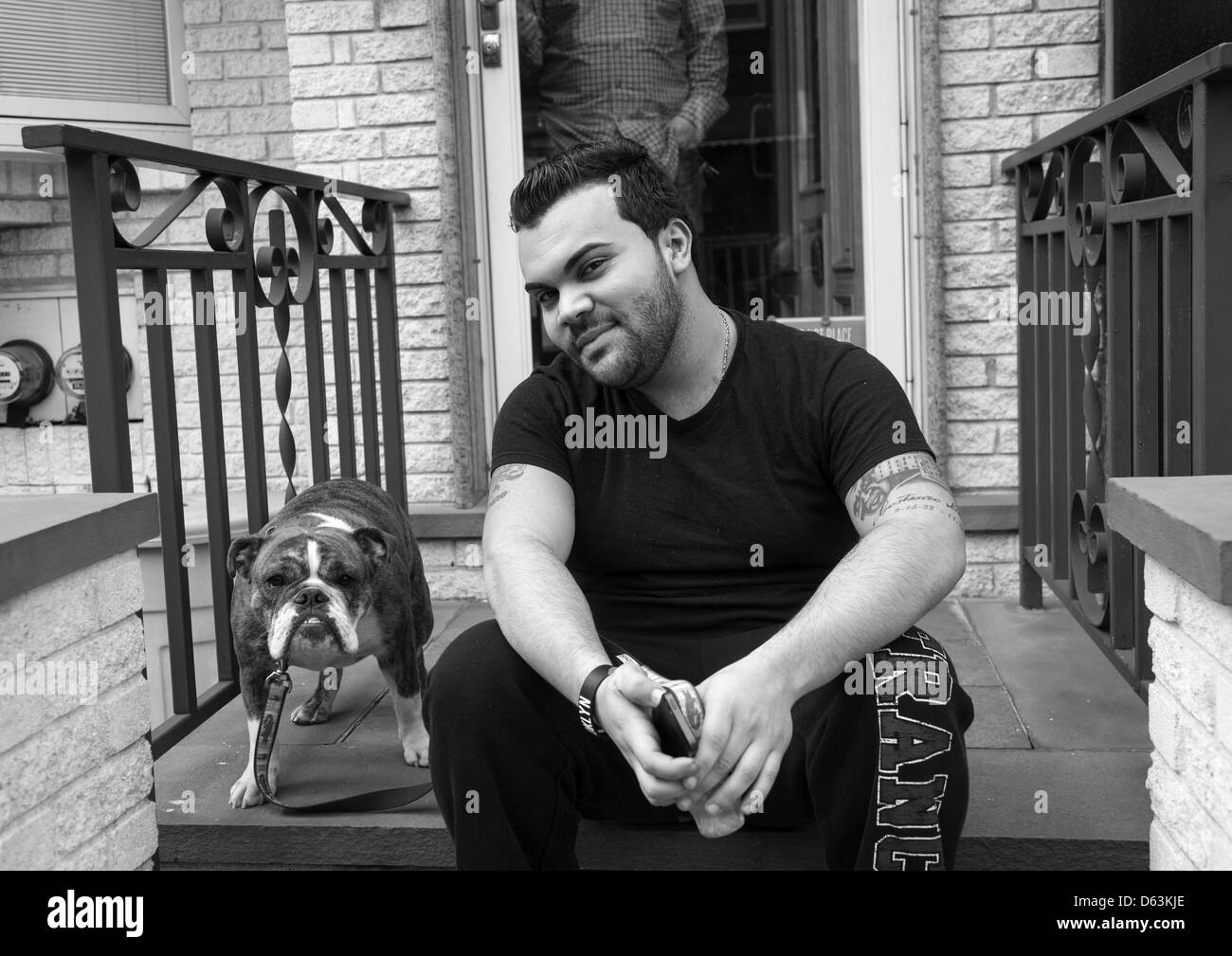 Mann mit seinem vertrauenswürdigen Bloodhound auf der Stoop von seiner Heimat, Williamsburg, Brooklyn. NEW YORK CITY Stockfoto