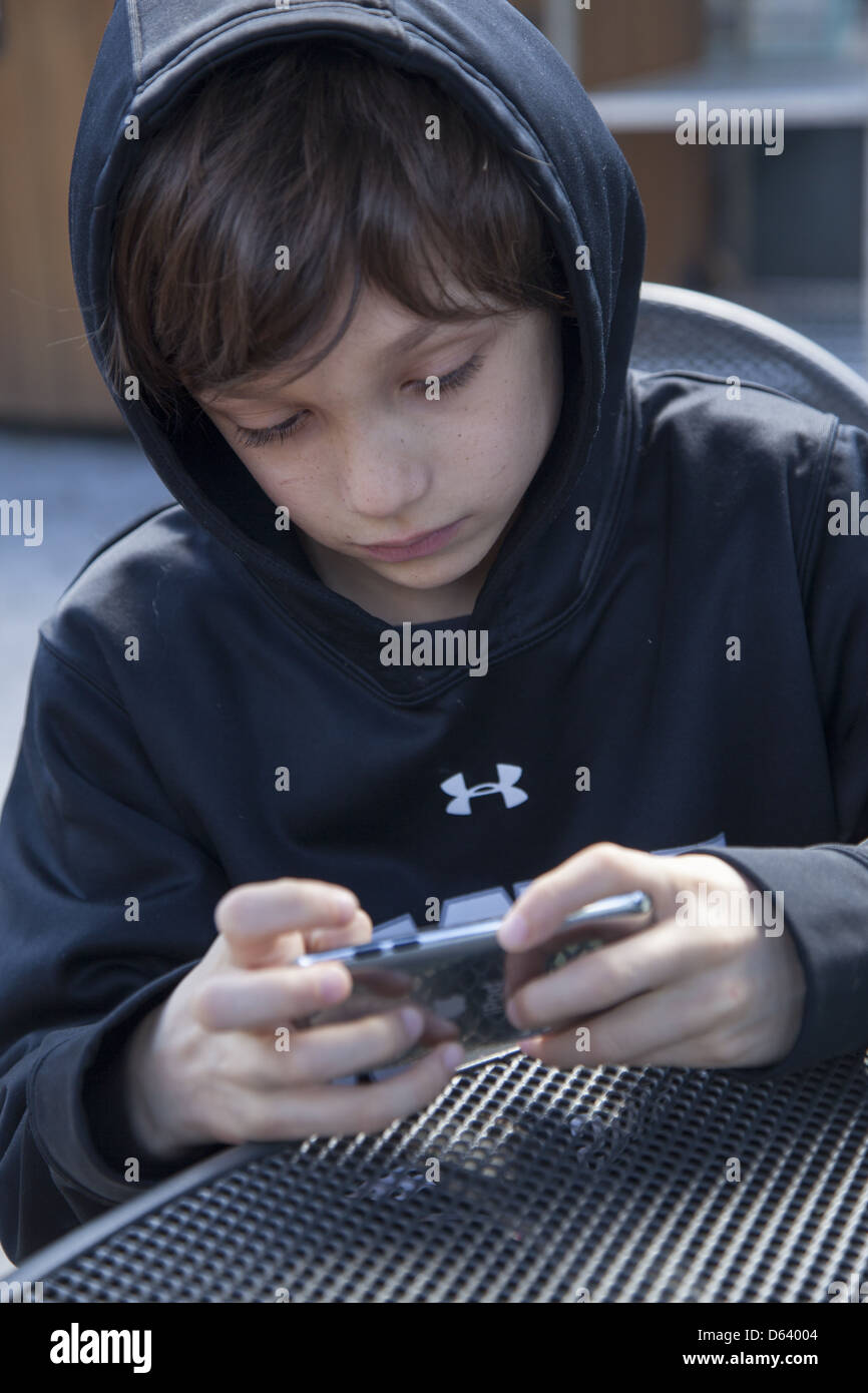 9 Jahre alter Junge spielt Minecraft auf seinem Ipod. Stockfoto