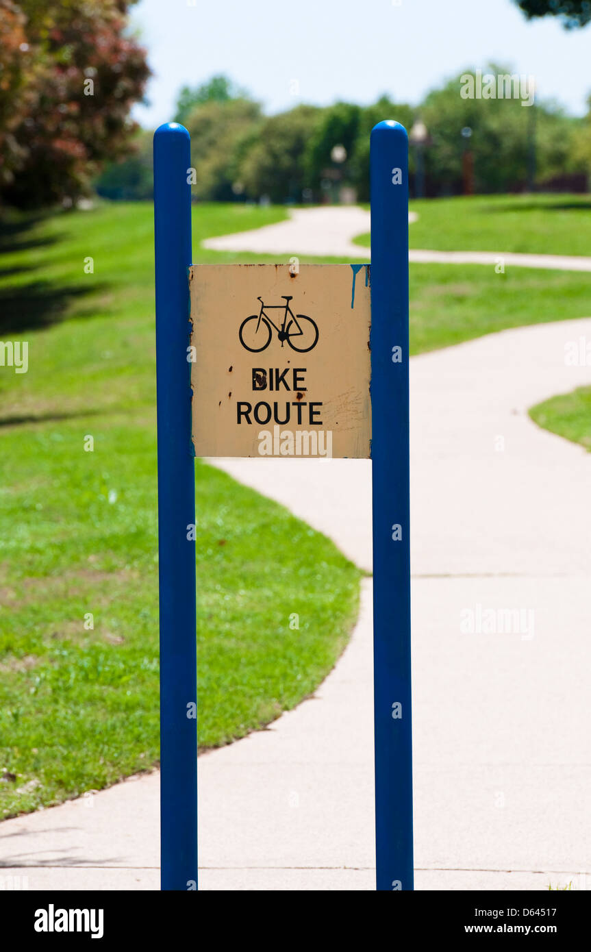 Blaue und gelbe rostigen Fahrrad Route Schild neben einem Pfad geschrieben. Stockfoto