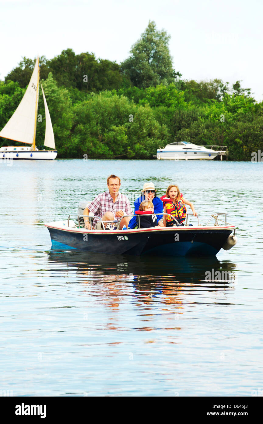 Junge attraktive Familie nehmen ein kleines Motorboot auf Ranworth breit Stockfoto