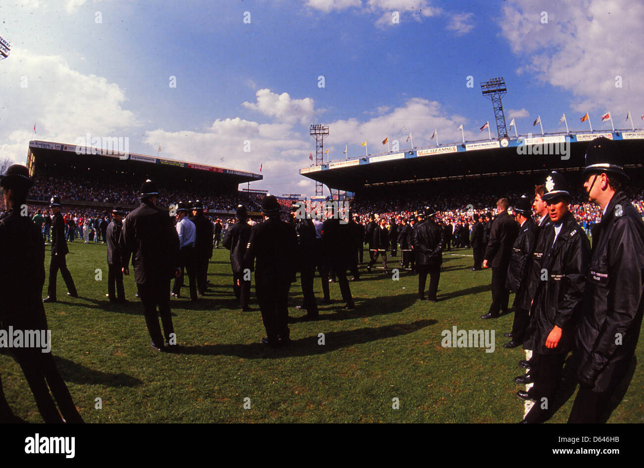 Archiv: Hillsborough Katastrophe 15. April 1989 FA Cup-Halbfinale-Liverpool V Nottingham Forest. Polizisten in der Mitte die Tonhöhe als Fans sind abgebildet unter Werbung Hordings vom Ende Kop, Unterstützer in der Leppings Lane Ende (ganz links) zu helfen. Das FA-Cup-Halbfinale zwischen Liverpool und Nottingham Forest wurde nach sechs Minuten des Spiels abgebrochen. in der Katastrophe starb 96 Fans in Liverpool Ende in der Leppings Lane, erdrückt. South Yorkshire Polizei war im Einsatz auf dem Spiel. Das Spiel wurde auf neutralem Boden von Hillsborough, Heimat der Sheffiel gespielt. Stockfoto