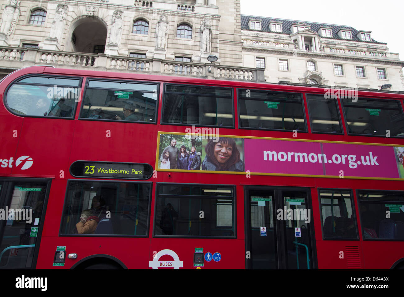 Ein roter Londoner Bus mit Mormonenwerbung fährt vor dem historischen Gebäude der Bank of England in der City of London, England, UK, vorbei und verbindet Stadtverkehr mit Glaubensbotschaften. Stockfoto