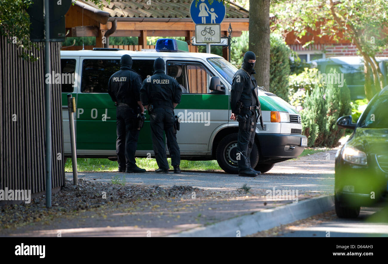 Polizei mit Gesichtsmasken stehen auf dem Gelände Hells Angels Präsident Frank H. in Bissendorf, Deutschland, 24. Mai 2012. Eine große Razzia gegen Rocker aus dem Bereich der Kiel findet derzeit in Niedersachsen statt. Foto: Jochen Luebke Stockfoto