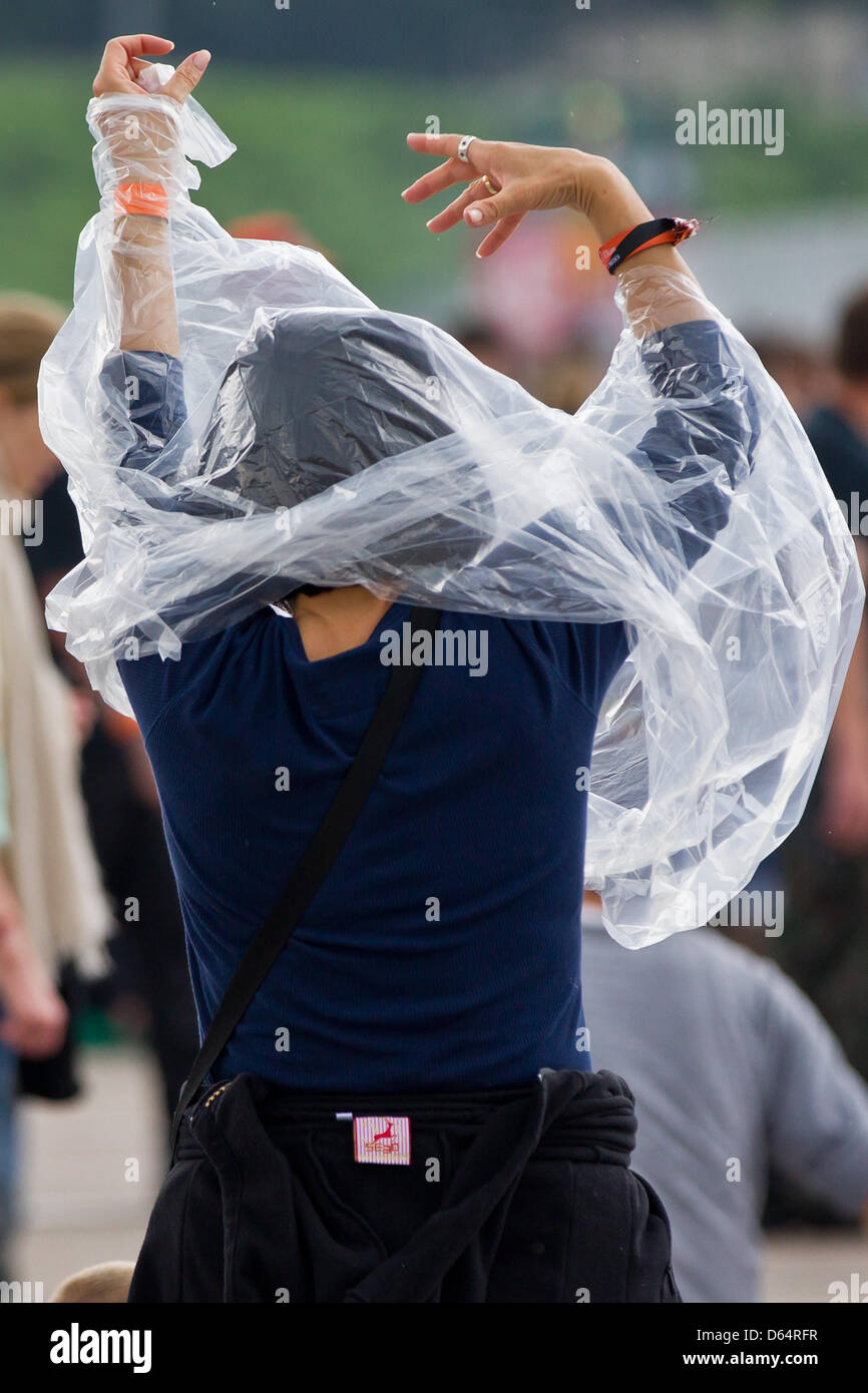 Eine Frau legt sich auf einen Regenponcho bei der Musik Festival Rock Im Park am Zeppelinfeld in Nürnberg, 3. Juni 2012. Bis zu 70,000 Fans der Rockmusik werden erwartet, um am Festival teilzunehmen. Foto: Daniel Karmann Stockfoto